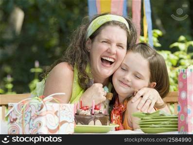 Mature woman embracing her daughter and laughing