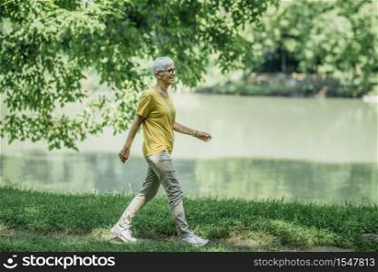 Mature Woman Enjoying Walking Exercise by the Lake