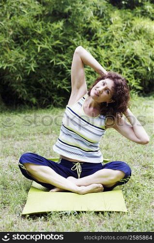 Mature woman exercising on the lawn