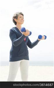 Mature woman exercising with dumbbells