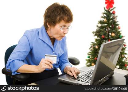 Mature woman finds a bargain shopping online for Christmas presents. Isolated on white.