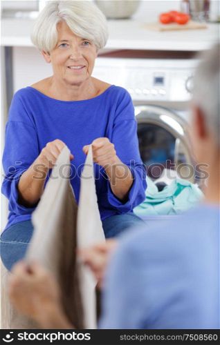 mature woman folding dry clothes