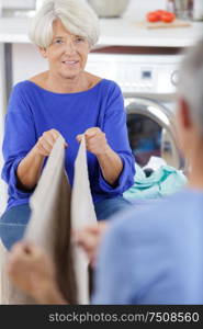 mature woman folding dry clothes