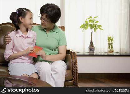Mature woman giving a greeting card to her granddaughter