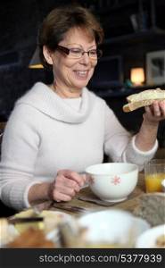 Mature woman having a winter breakfast