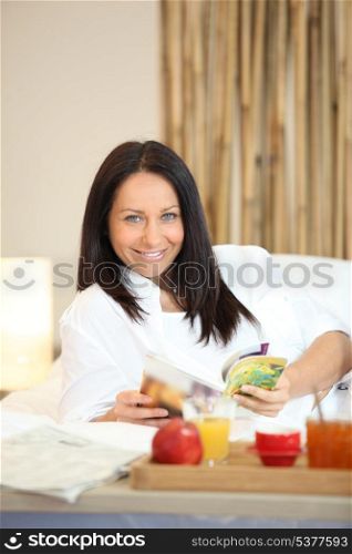 mature woman having breakfast and relaxing on the sofa