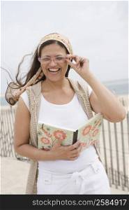 Mature woman holding a book and laughing