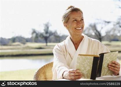 Mature woman holding a book and smiling