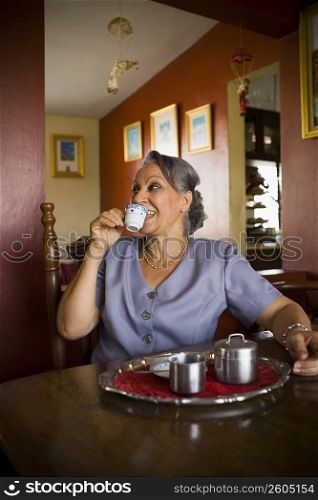Mature woman holding a cup of tea and smiling
