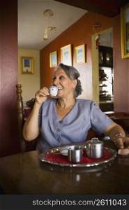 Mature woman holding a cup of tea and smiling