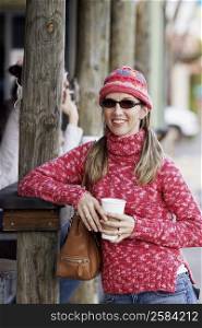 Mature woman holding a disposable cup and smiling