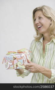 Mature woman holding a gift and smiling