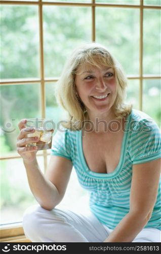 Mature woman holding a glass of wine and smiling