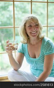 Mature woman holding a glass of wine and smiling