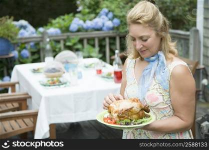Mature woman holding a plate of roast turkey