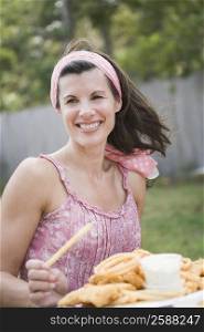 Mature woman holding a plate of snacks and smiling