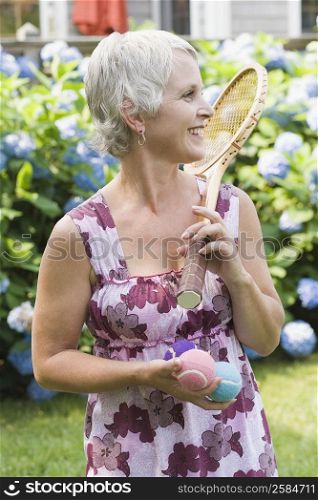 Mature woman holding a tennis racket and tennis balls