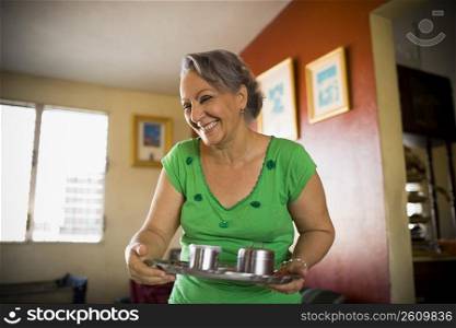 Mature woman holding a tray and smiling