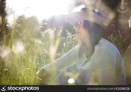 Mature woman in cowboy hat with blade of grass in her mouth