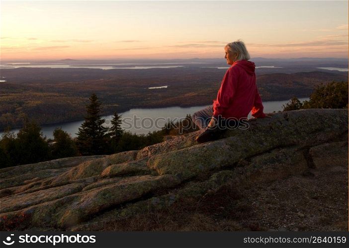 Mature woman in natural setting watching the sunset