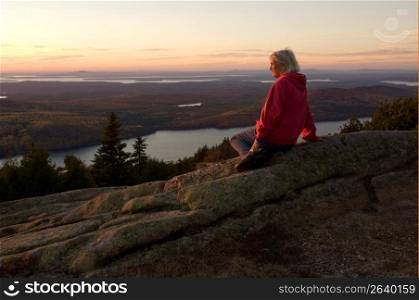 Mature woman in natural setting watching the sunset