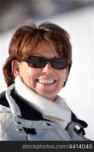Mature woman in sunglasses on a ski slope