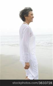 Mature woman in white clothing at waters edge