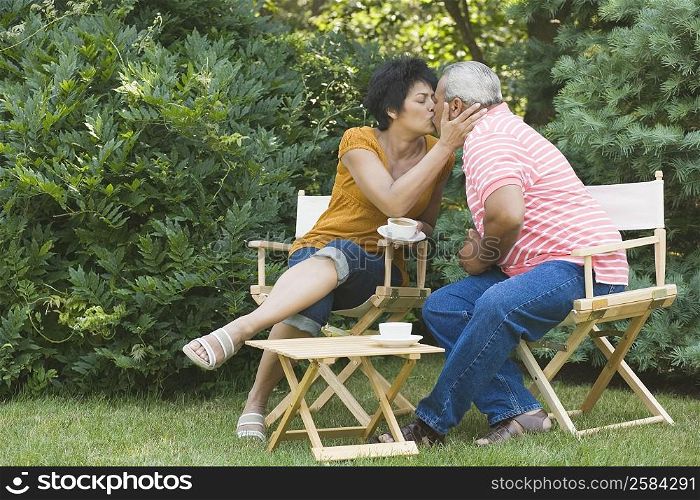Mature woman kissing a senior man in a garden