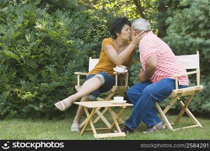 Mature woman kissing a senior man in a garden