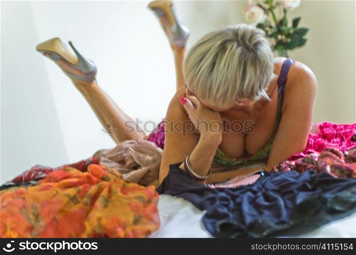 Mature woman lies on untidy bed
