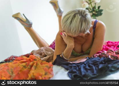 Mature woman lies on untidy bed