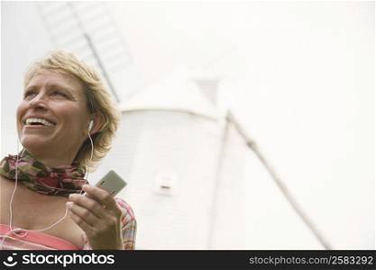 Mature woman listening to an mp3 player and smiling
