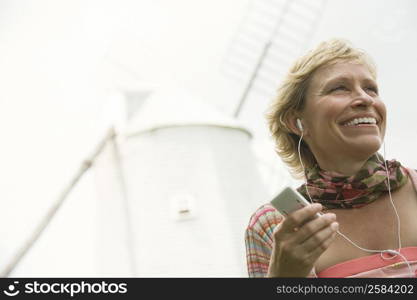 Mature woman listening to an mp3 player and smiling