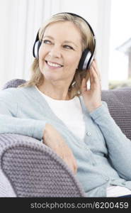 Mature Woman Listening To Music On Wireless Headphones