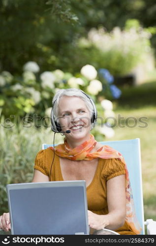 Mature woman listening to music with headphones