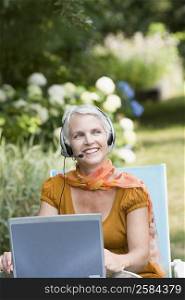 Mature woman listening to music with headphones