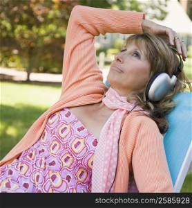 Mature woman listening to music with headphones