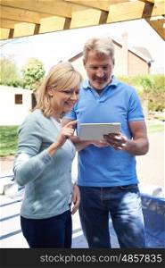 Mature Woman Looking At Design On Digital Tablet With Landscape Gardener