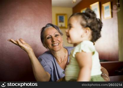Mature woman looking at her granddaughter and smiling