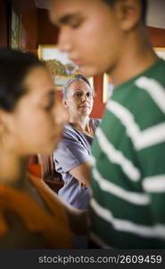 Mature woman looking at her granddaughter embracing a young man