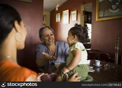 Mature woman looking at her granddaughter with another standing beside her