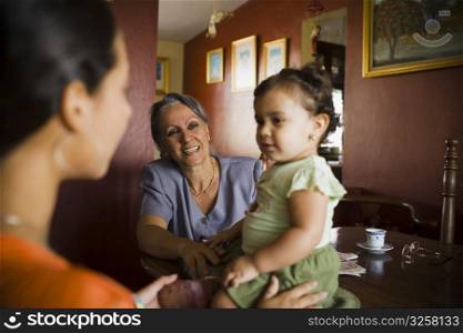 Mature woman looking at her granddaughter with another standing beside her
