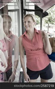 Mature woman looking at the mannequin in a window display