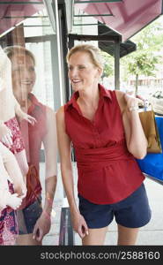 Mature woman looking at the mannequin in a window display