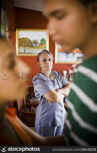 Mature woman looking away with her granddaughter embracing a young man