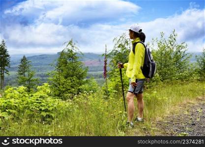 Mature woman looking out to vast wilderness while hiking