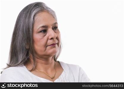 Mature woman lost in thoughts over white background