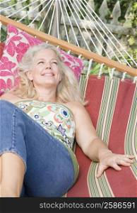 Mature woman lying in a hammock and smiling