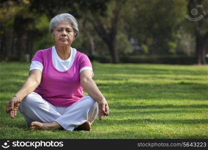 Mature woman meditating outdoors