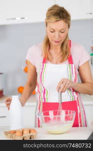 mature woman mixing ingredients for delicious tasty cake or tart